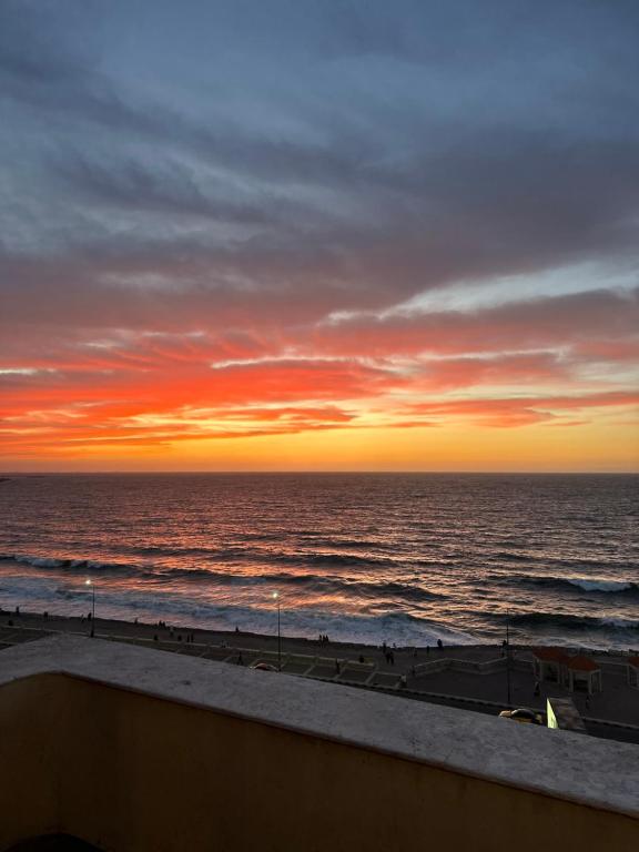 een zonsondergang over de oceaan met mensen op het strand bij Haidar House a private rooms for men only at shared apartment غرف خاصه للرجال فقط in Alexandrië
