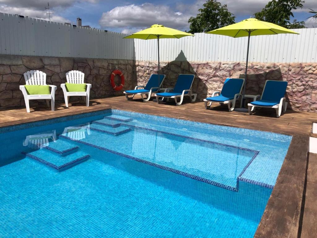 a swimming pool with chairs and umbrellas next to a pool at Hakuna Matata in Cano