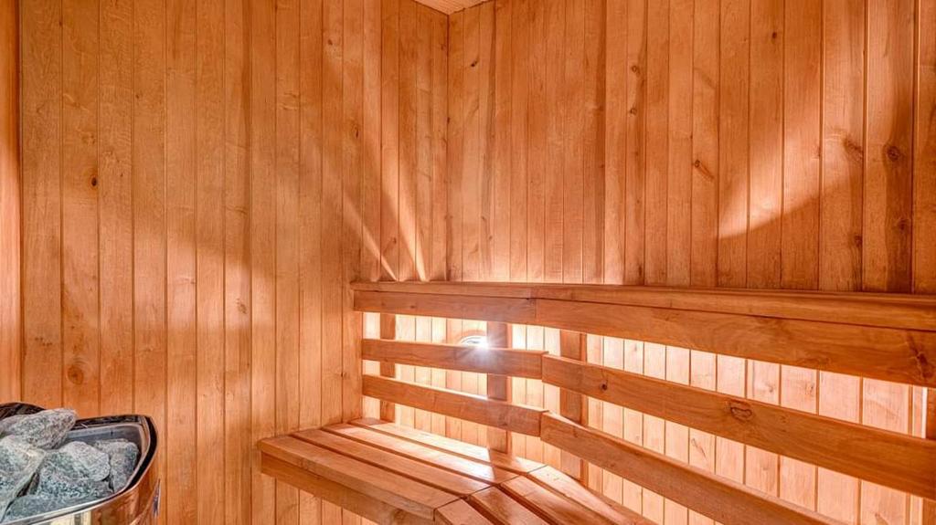 een houten interieur van een sauna met zonneschijn bij Deluxe Hostel with Sauna, TV, Bidet, Kitchen & Parking in Kaunas