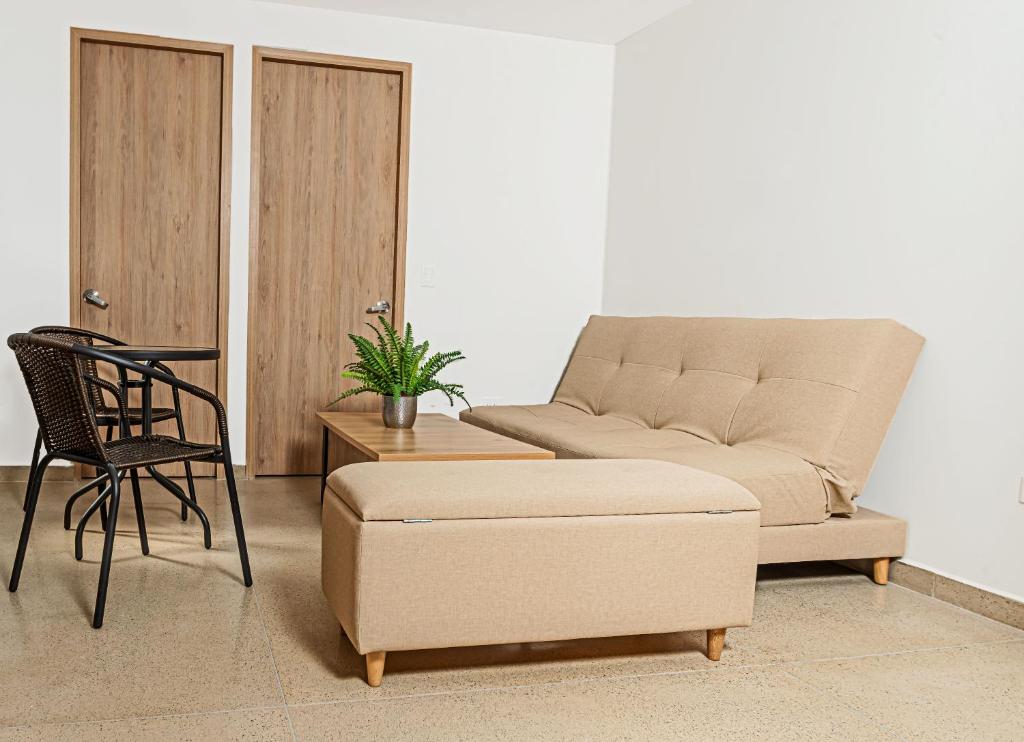 uma sala de estar com um sofá e uma cadeira em Apartamentos Montecarlo em Medellín