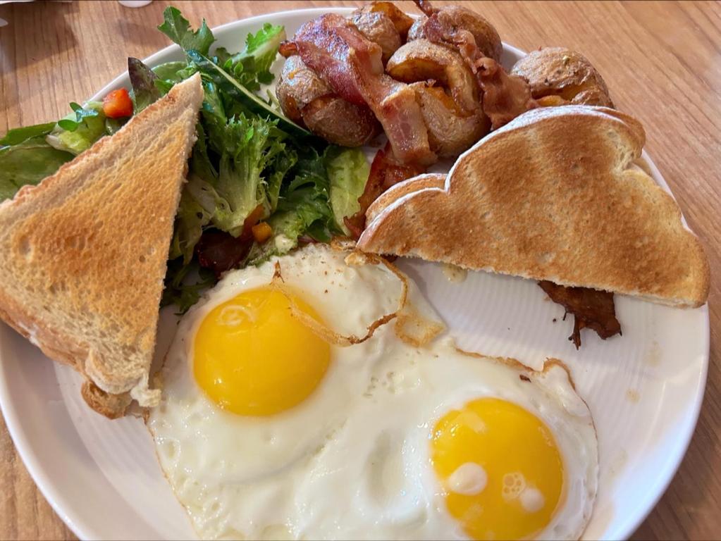a plate of breakfast food with eggs and toast at Harrison Spa Motel in Harrison Hot Springs