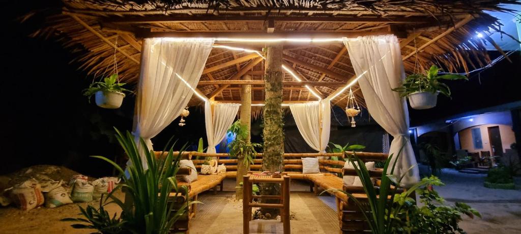 バンタヤン島にあるエドサン アパートのソファ付きの部屋、植物のあるテントが備わる部屋