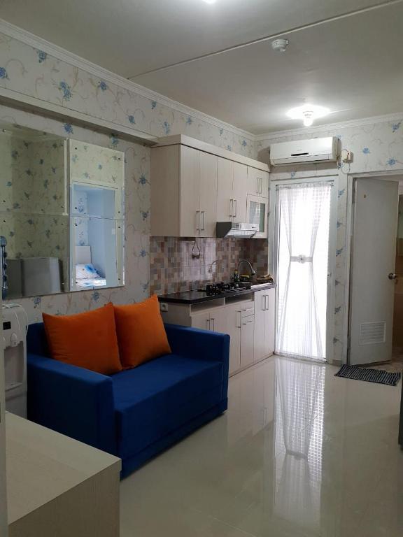 ein Wohnzimmer mit einer blauen Couch in einer Küche in der Unterkunft Apartemen Green Pramuka City Type 2BR Full Furnish in Jakarta