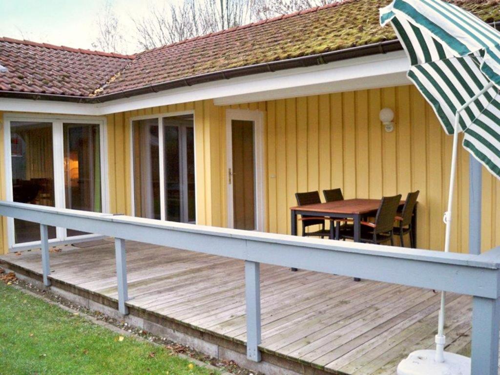 une terrasse avec une table et un parasol sur une maison dans l'établissement Reiher 6, à Mirow