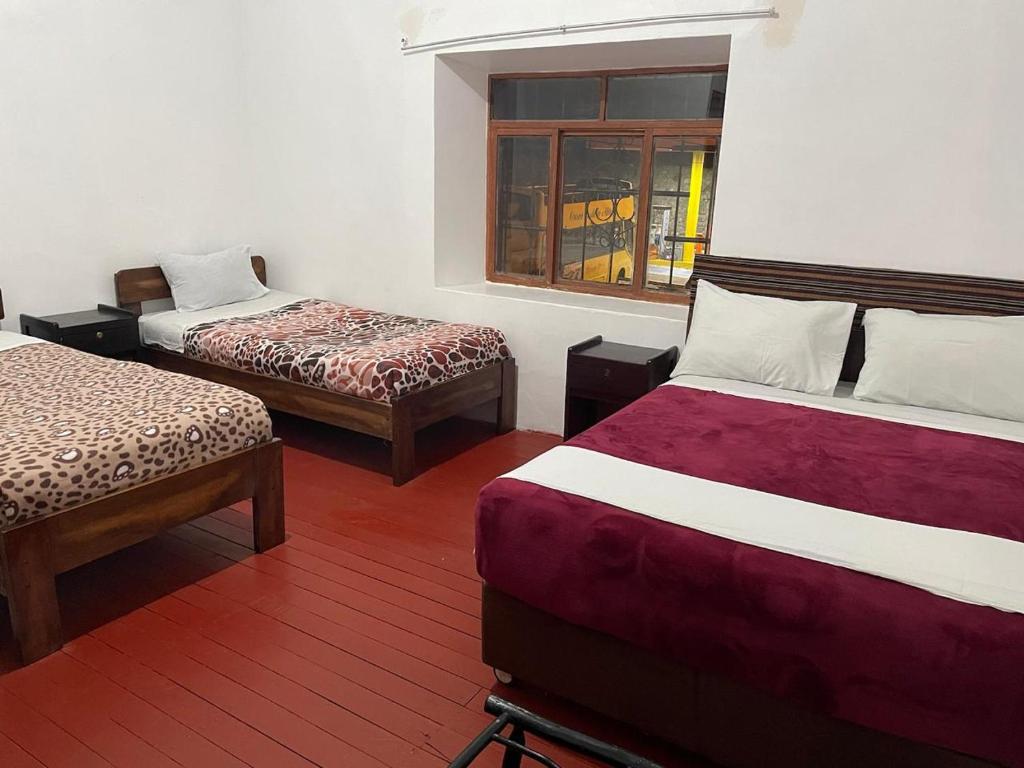 a room with two beds and a window at Mundo Viajero Saphy in Cusco
