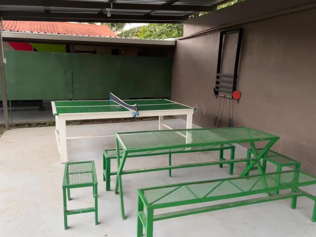 een tafeltennistafel en 2 stoelen voor een gebouw bij VLR habitaciones in La Ceiba