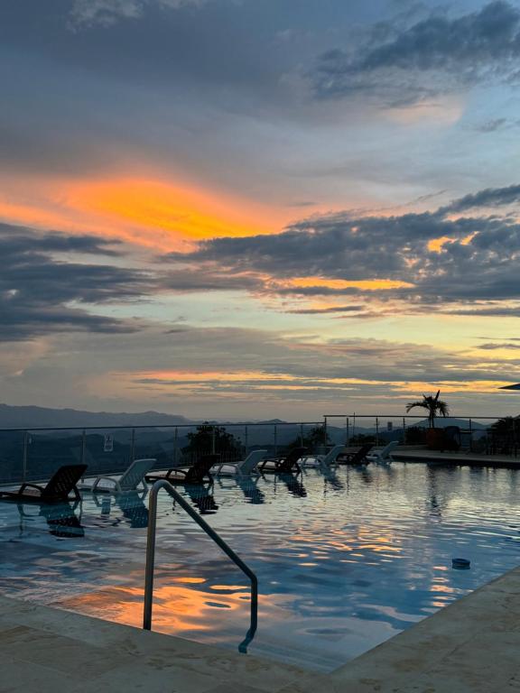une piscine avec vue sur le coucher du soleil en arrière-plan dans l'établissement Apto panoramico. La mesa-cundinamarca, à La Mesa