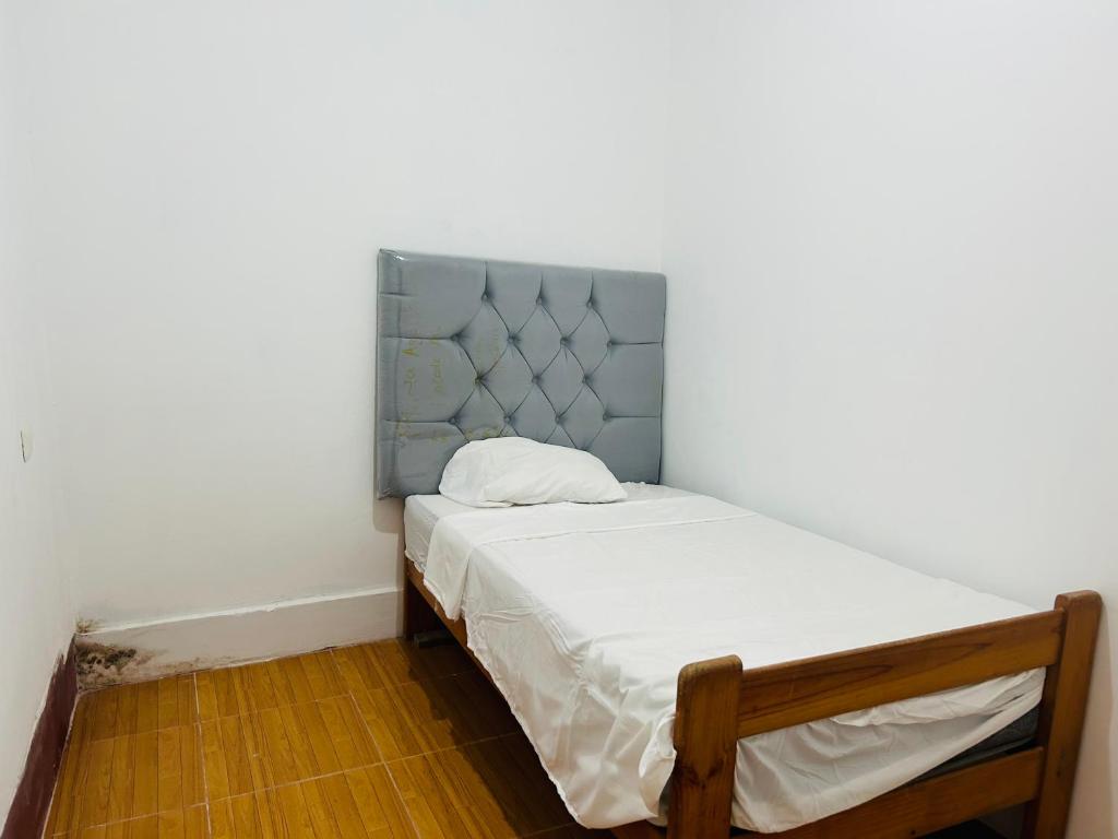 Departamento de 3 habitaciones في بوكالبا: سرير صغير مع اللوح الأمامي الأزرق في الغرفة