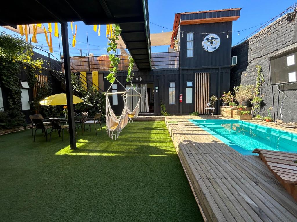 a backyard with a hammock and a swimming pool at Colmena House Villa Alemana in Villa Alemana