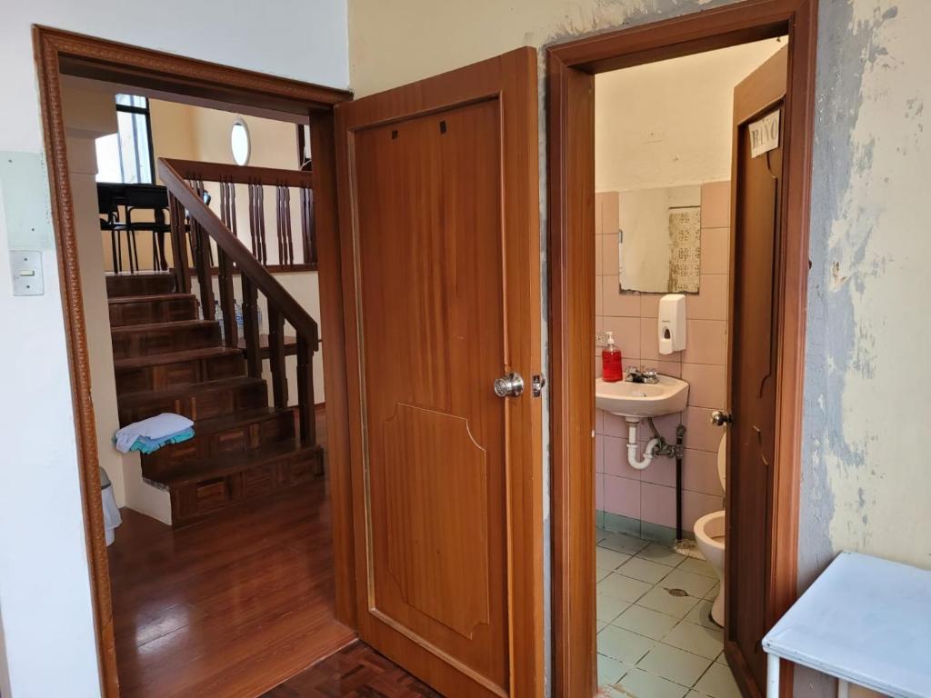 baño con lavabo y aseo y escalera en Casa Colon Quito Bed & Breakfast Hostel, en Quito
