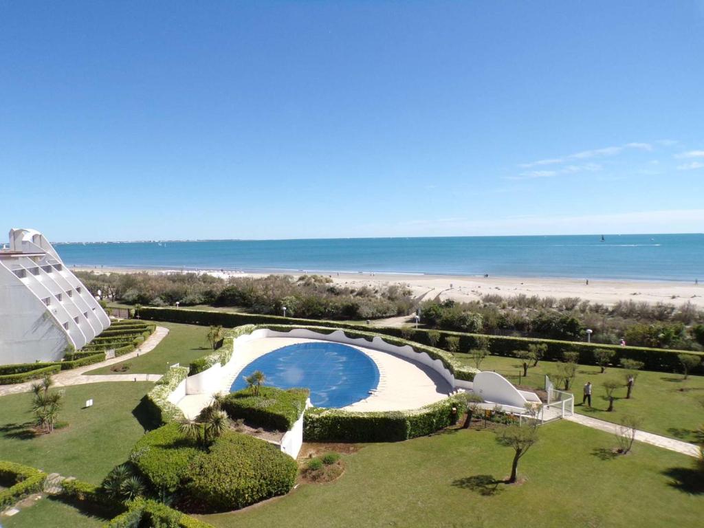 - une vue sur la piscine et la plage dans l'établissement Appartement 2 pièces avec piscine, garage, et WIFI à La Grande-Motte - FR-1-328-220, à La Grande Motte
