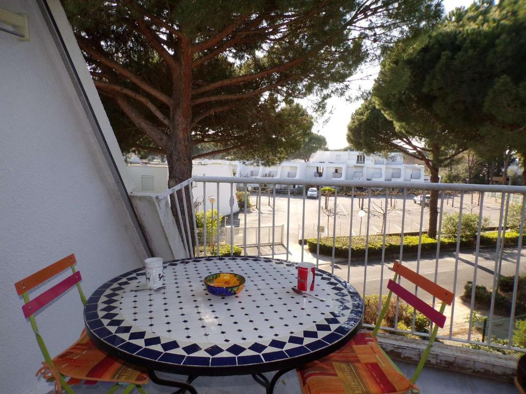 une table et des chaises bleues et blanches sur un balcon dans l'établissement Studio Calme et Moderne avec Parking Privé, à 500m de la Plage - La Grande-Motte - FR-1-328-241, à La Grande Motte