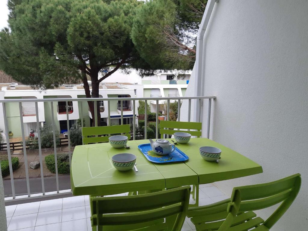 einen grünen Tisch auf einem Balkon mit Schalen drauf in der Unterkunft Studio La Grande-Motte, 1 pièce, 4 personnes - FR-1-328-255 in La Grande-Motte