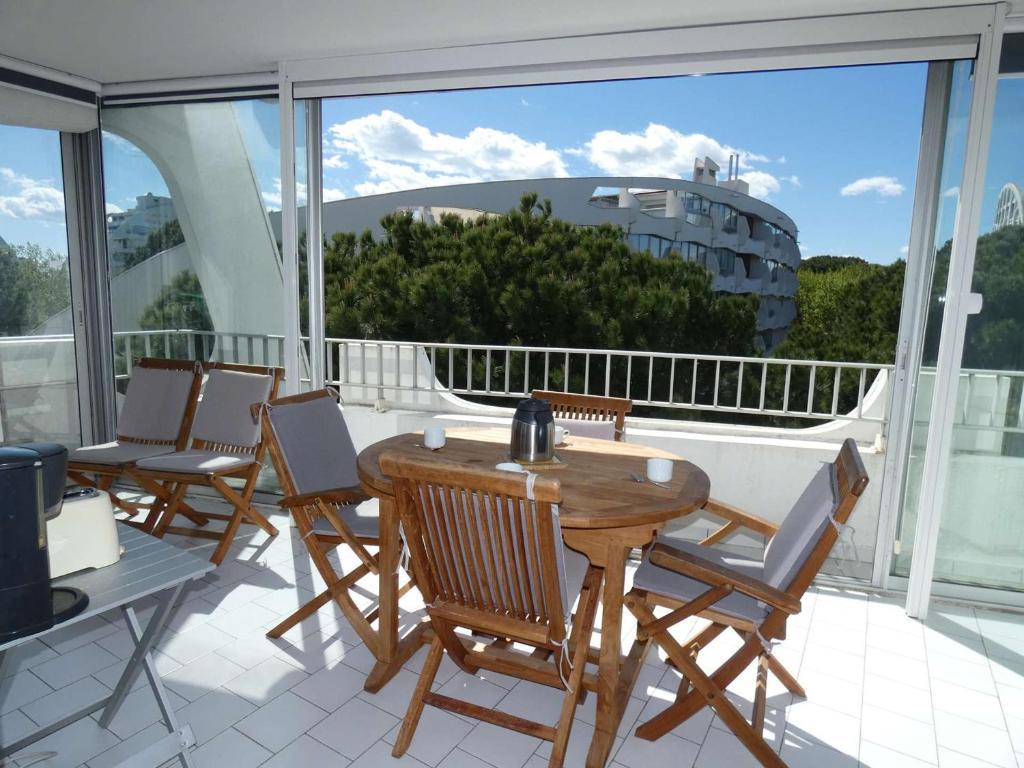 un balcon avec des chaises et une table en bois sur un balcon dans l'établissement Studio cabine avec piscine, climatisation, garage, à 300m plage - FR-1-328-259, à La Grande Motte