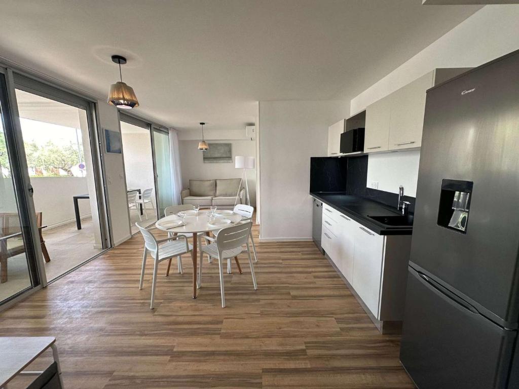 une cuisine et une salle à manger avec une table et des chaises dans l'établissement Appartement Climatisé, Proche Plage et Commerces, 4 Pers., Parking Privé, Quartier du Couchant - FR-1-328-235, à La Grande Motte