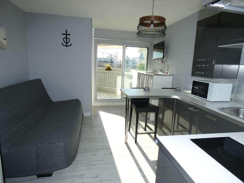 une cuisine avec un canapé et une table dans l'établissement Studio Cabine Moderne, 100m de la Plage, Parking et Wifi Inclus - FR-1-328-253, à La Grande Motte