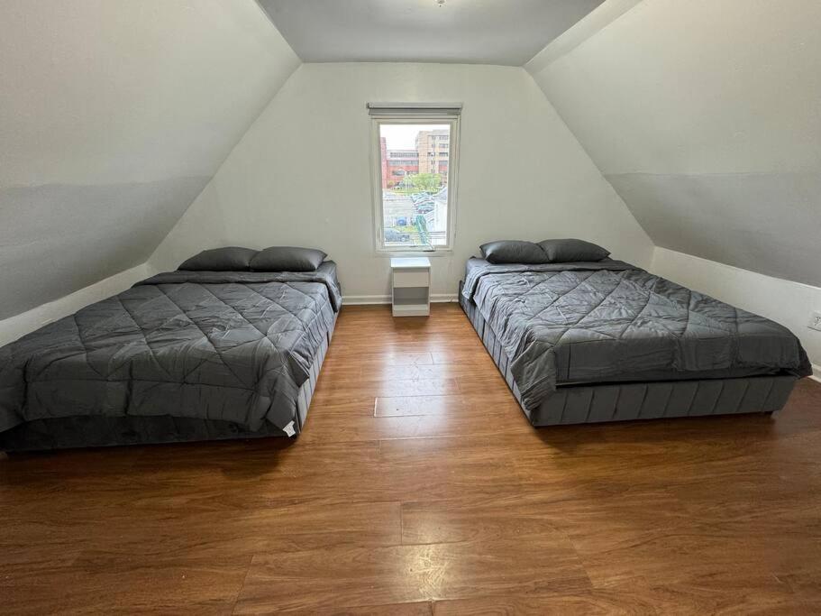 una camera mansardata con due letti e una finestra di Comfy Family Home -Adjacent To NYC: 15 Guests a Passaic