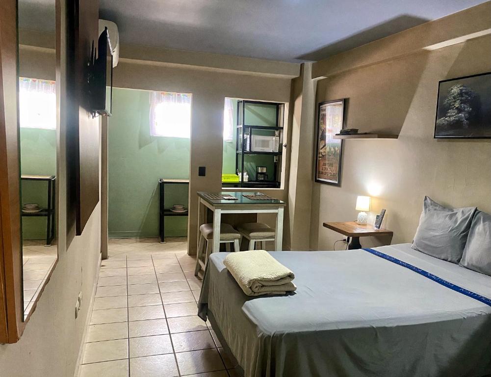 a bedroom with a bed and a desk in it at Mini Suite Apartamento in San Pedro Sula