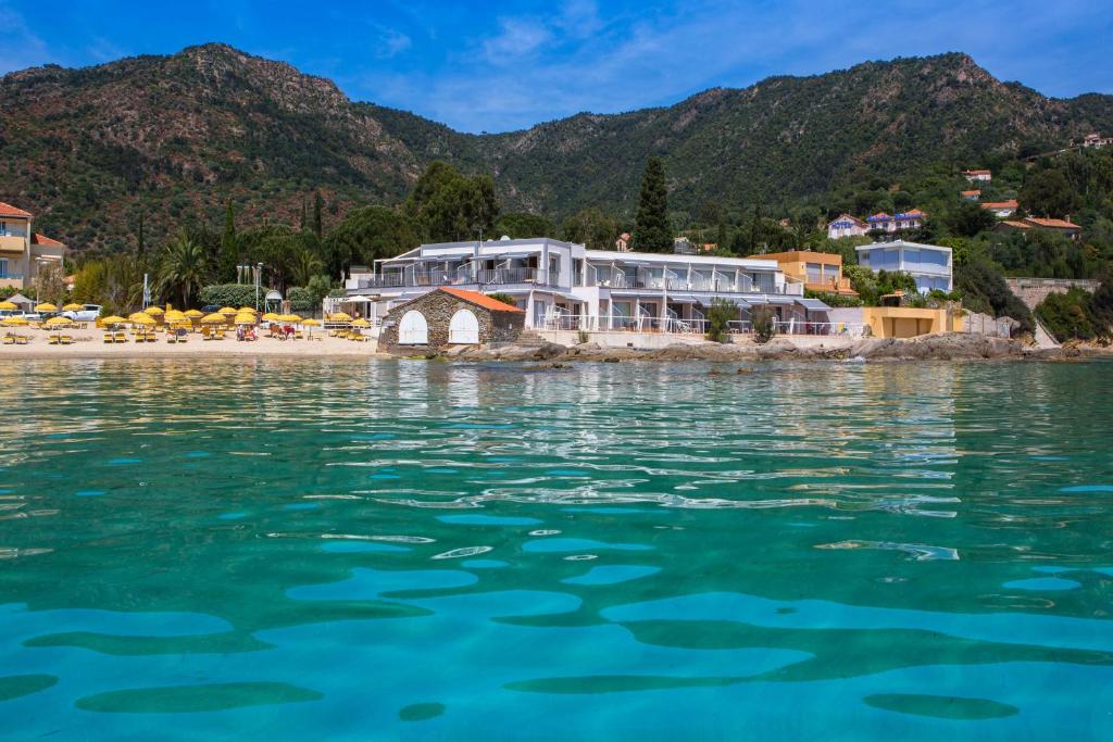 un complejo a orillas de una playa en Roc Hotel - Hôtel 4 étoiles les pieds dans l'eau en Le Lavandou