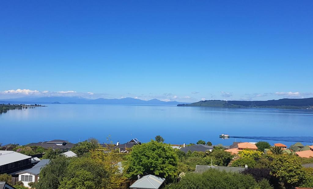 a view of a large body of water with houses at Muritai House - Taupo in Taupo