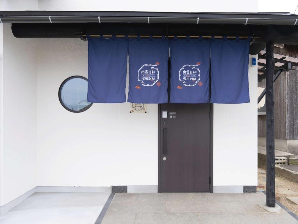 Izumo Biyori Horikawa Villa - Vacation STAY 28459v في إزومو: مبنى وستارة زرقاء ومرآة