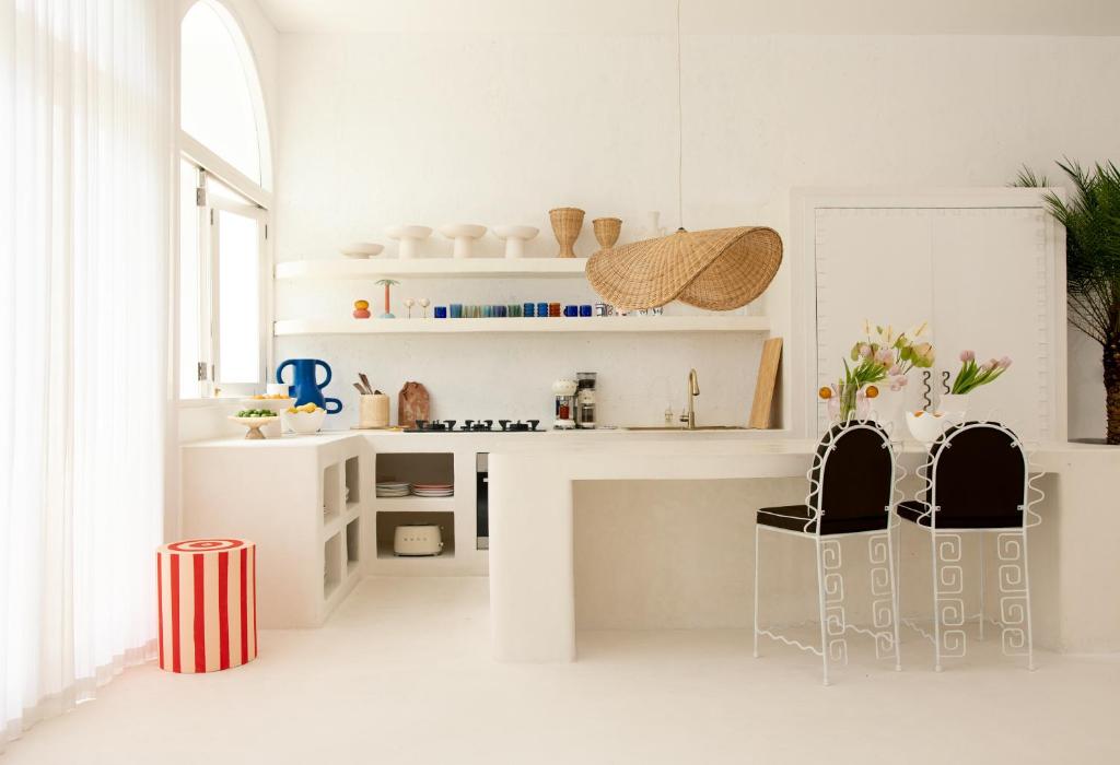 a white kitchen with two chairs and a counter at La Playa, Bali in Munggu