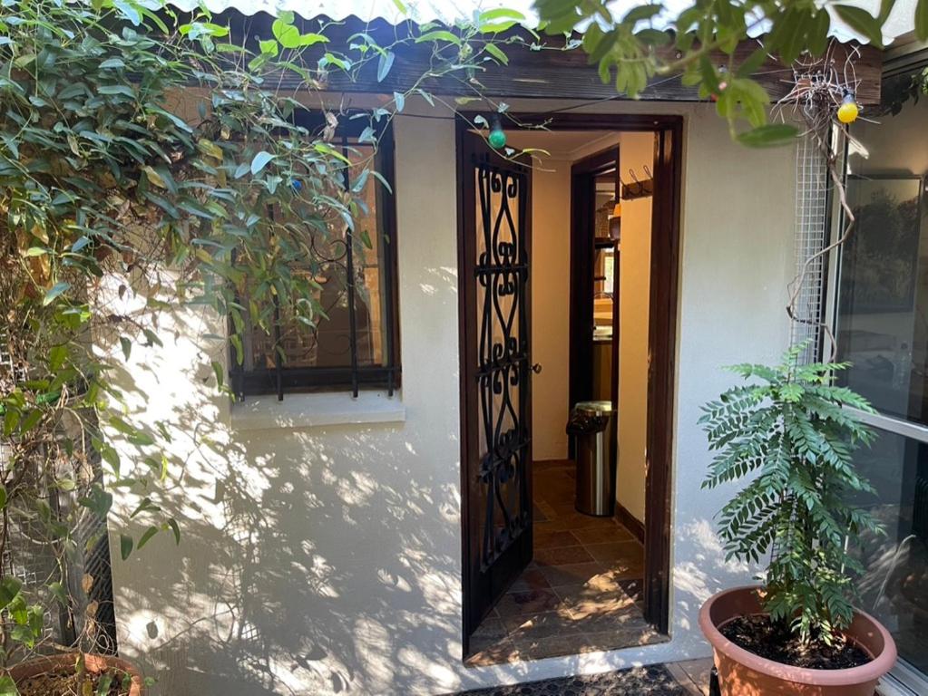 una puerta abierta a una casa con una planta en Alice's Granny Flat en Alice Springs