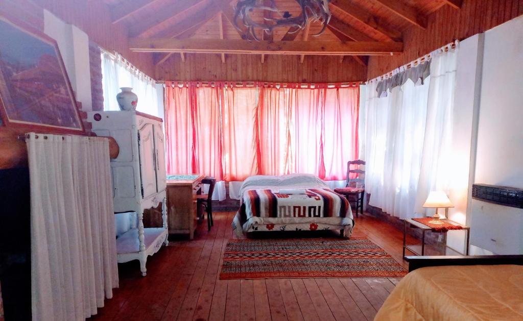 um quarto com uma cama e cortinas vermelhas em Hospedaje BRC em San Carlos de Bariloche