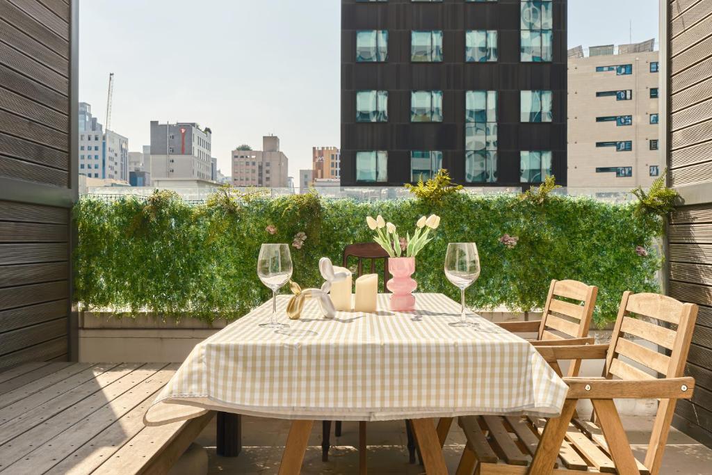 a table with wine glasses and vases on a balcony at Seoul COMOCASA Premium Terrace Residence in Seoul