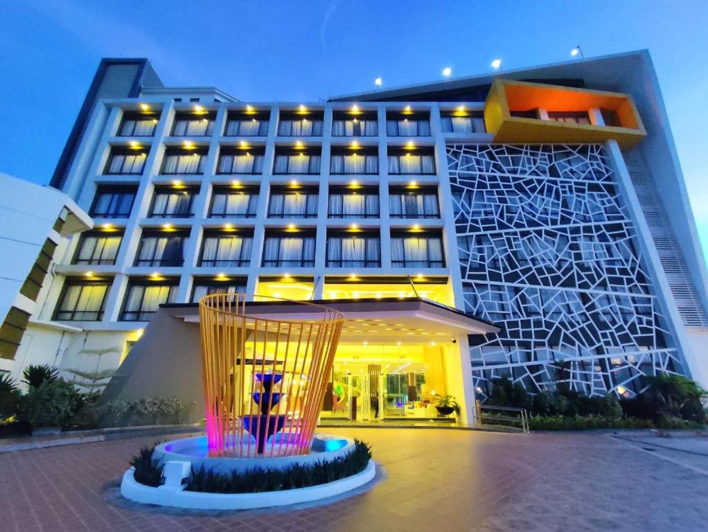 ein Hotelgebäude mit einer Skulptur davor in der Unterkunft Winrich Hotel in Lapu Lapu City