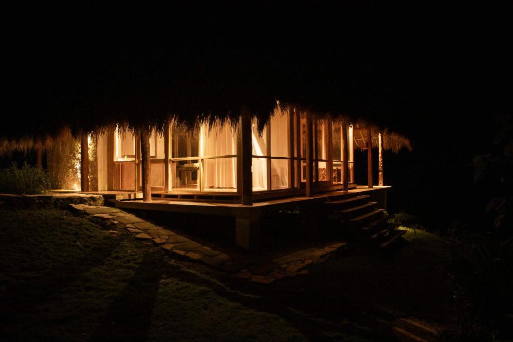une petite cabane avec un toit de chaume la nuit dans l'établissement SumbaFarmHouse, à Patiala Bawa