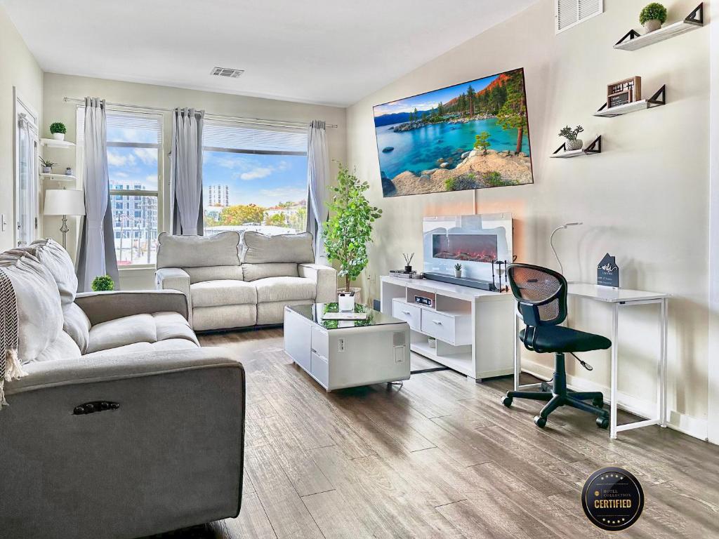 een woonkamer met een bank en een bureau met een televisie bij Spacious Riverfront 2 Bed 2 Bath 15 mins to NYC in Yonkers