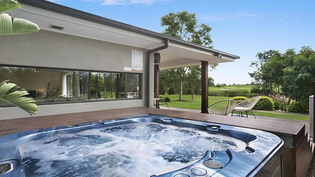 a hot tub on the deck of a house at 1oak - The Vintage in Pokolbin