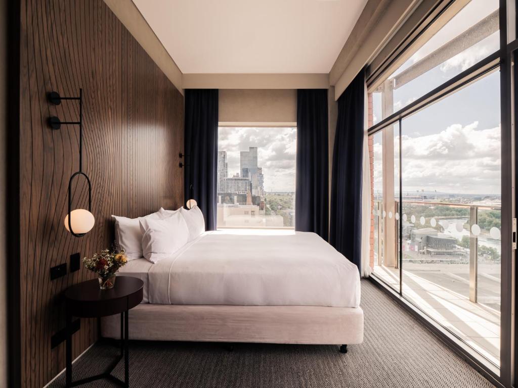 a hotel room with a bed and a large window at DoubleTree by Hilton Melbourne in Melbourne