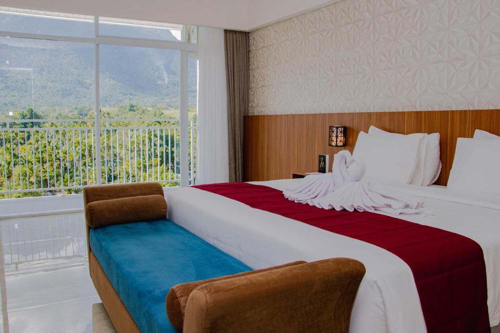 a bedroom with a large bed with a window at Horison Sentani in Sentani