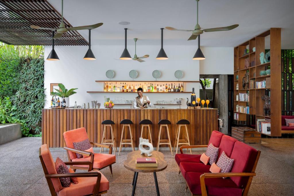 a living room with chairs and a bar at Viroth's Hotel in Siem Reap