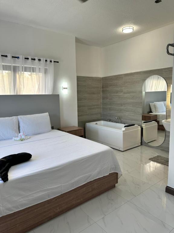 ein Schlafzimmer mit einem großen Bett und einer Badewanne in der Unterkunft White Signature Suite in Kingston