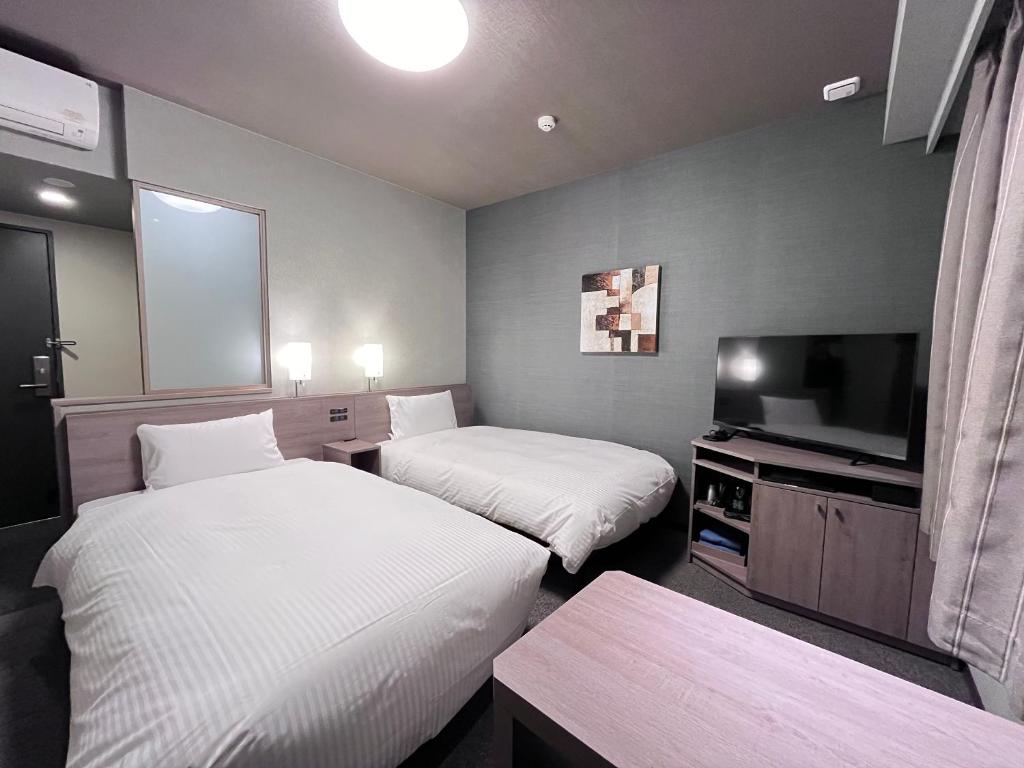 Postel nebo postele na pokoji v ubytování Hotel Route Inn Kuwana