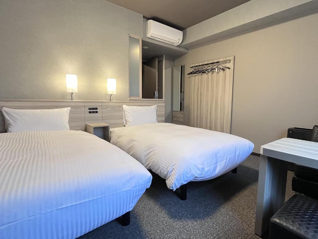 Postel nebo postele na pokoji v ubytování Hotel Route Inn Kuwana