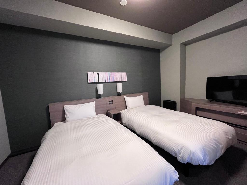 Postel nebo postele na pokoji v ubytování Hotel Route Inn Kuwana