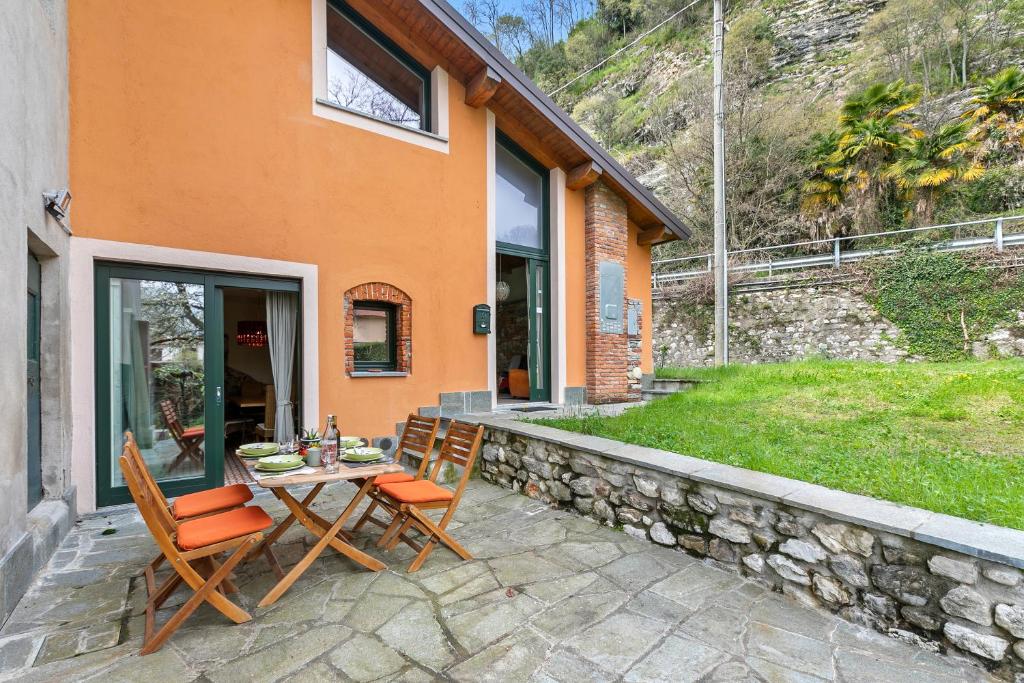 un patio con mesa y sillas frente a una casa en La Maison Du Lac - Happy Rentals, en  Monvalle 