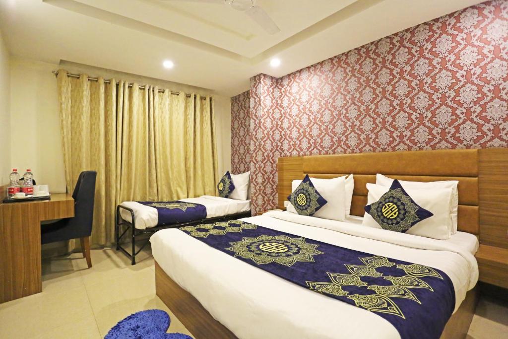 Habitación de hotel con 2 camas y escritorio en Hotel Ronit Royal - New Delhi Airport en Nueva Delhi