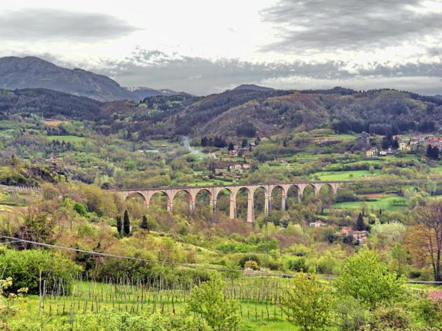 a bridge in the middle of a valley with a town at La Cerreta Affittacamere in Poggio