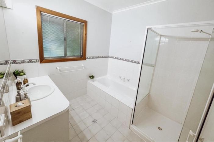 a white bathroom with a sink and a shower at Paringa Riverside Resort in Renmark