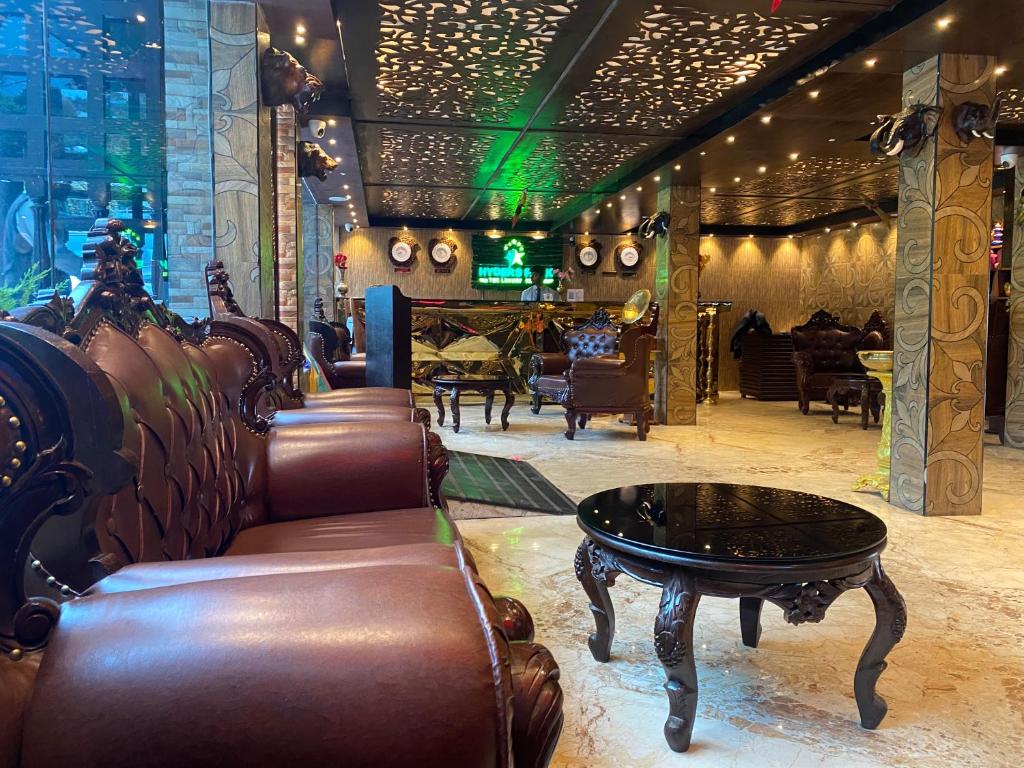a bar with leather chairs and a table in a room at HYDERS PARK- THE LUXURY HOTEL in Kodaikānāl