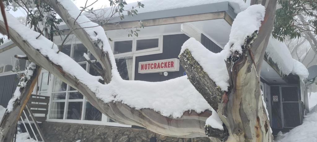 una señal en el lado de un edificio en la nieve en Nutcracker Ski Club en Mount Buller