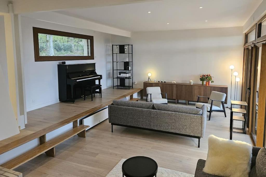 - un salon avec un canapé et un piano dans l'établissement La Maison du Grand Sapin, à Saint-Gatien-des-Bois