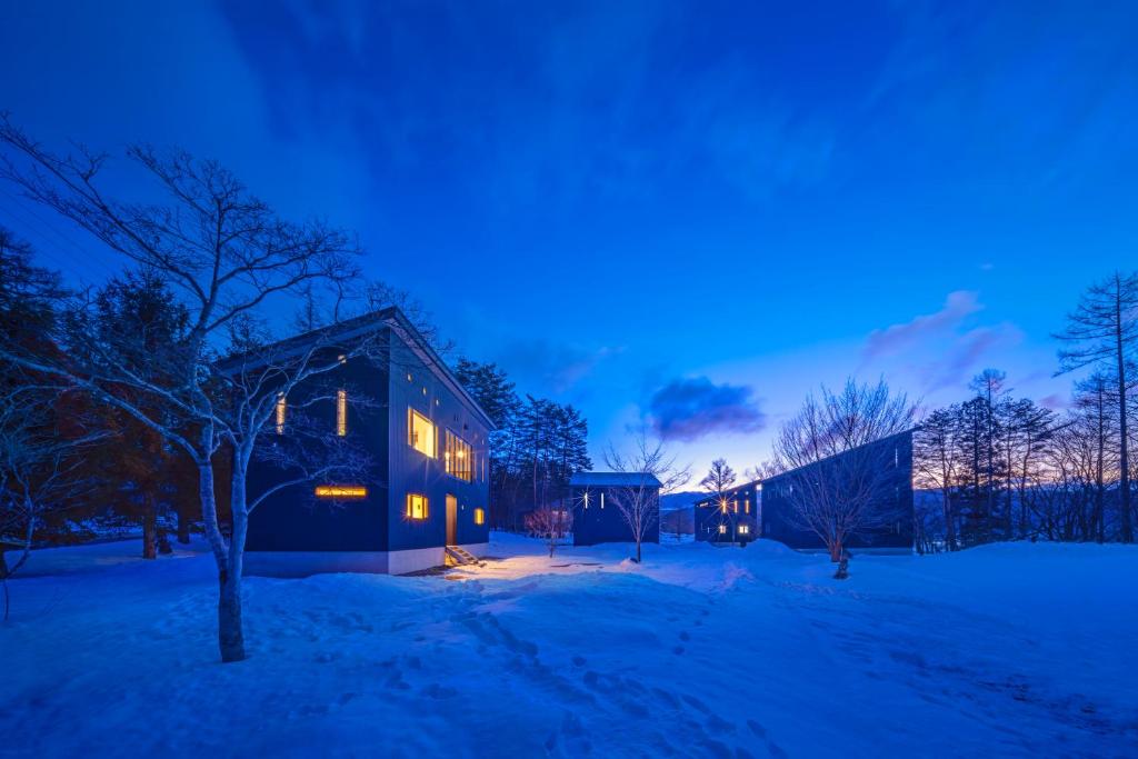 a house in the snow at night at Powdersuites by The Hakuba Collection in Hakuba