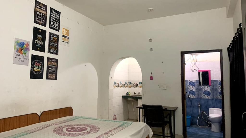 a bedroom with a bed and a table and a window at Accueillir PG in Jhājra