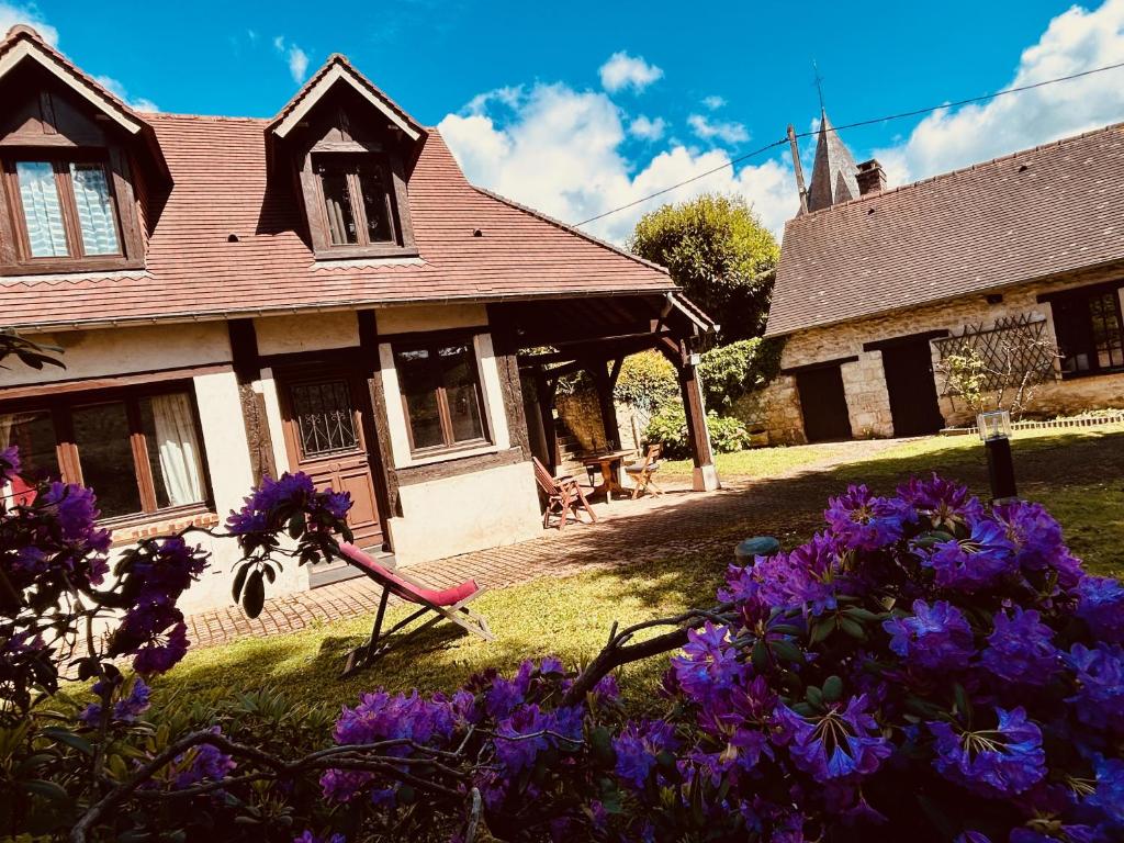 dom z fioletowymi kwiatami przed nim w obiekcie LIAGE - La Maison qui relie w mieście Saint-Marcel